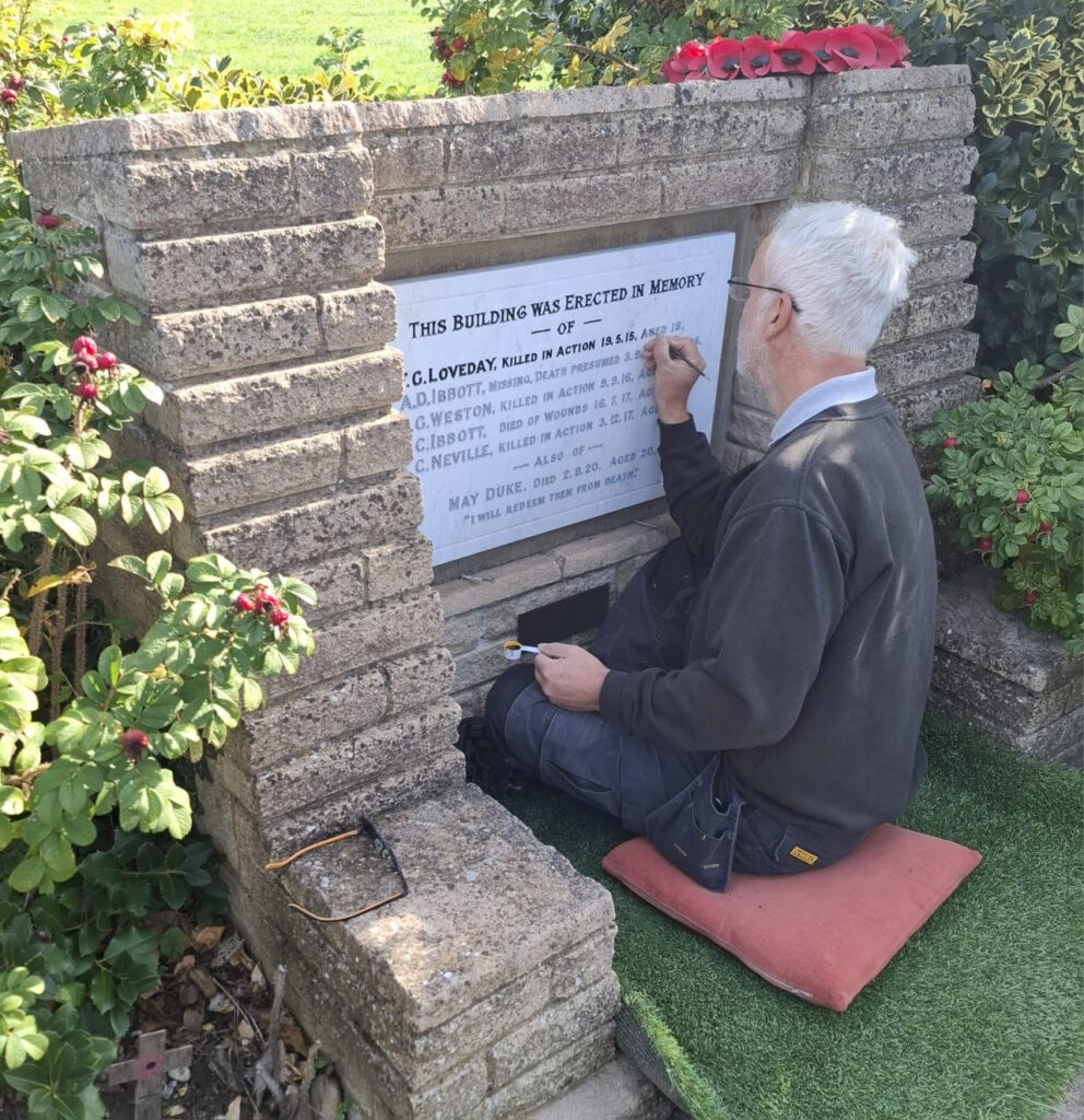 Work being undertaken to repaint the lettering on Oxhey Village War Memorial, on 24 September 2025
