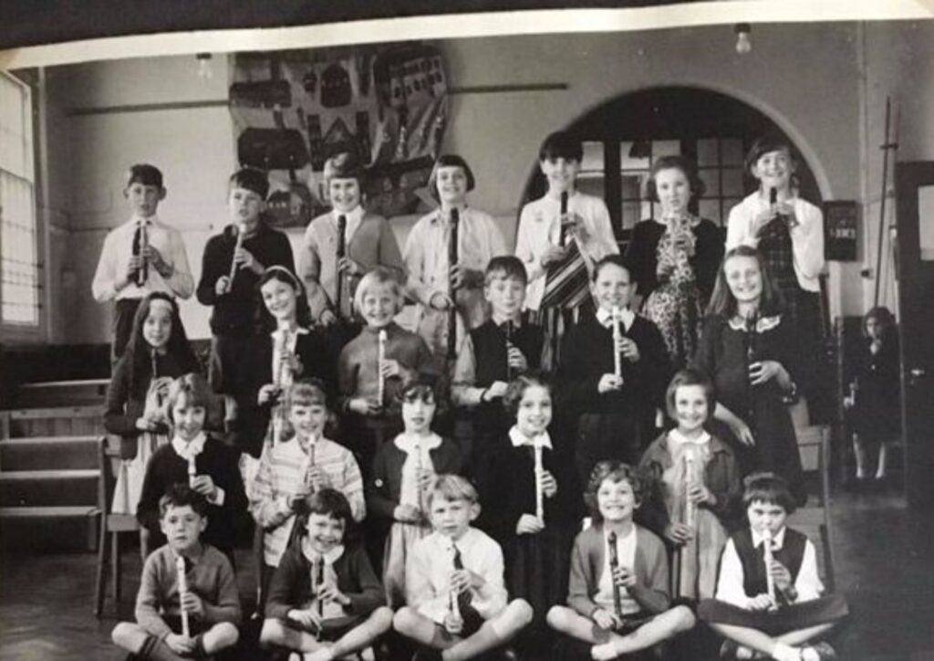 A photo from Pauline Beer's memoirs showing children playing musical instruments at Bushey Manor School