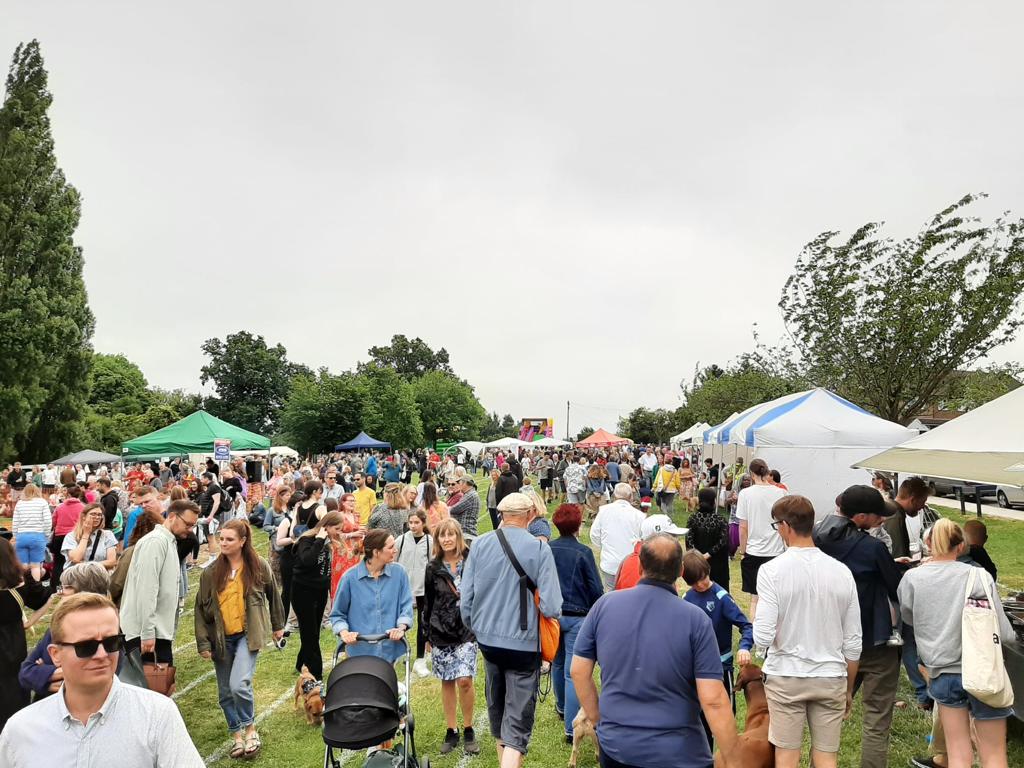 People walking on the village green at OVEG's Oxhey Village Summer Fayre on Saturday 18 June 2022
